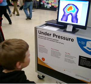 Child sits and watches his body map change on the Tactilus® Sensor System display