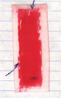 Figure 5. Pressure measuring film, medium pressure, placed on the top (left) and at the bottom (right) of the sample. The arrows indicate the location of the superconducting strand.