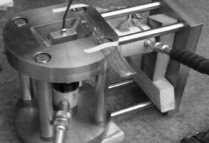 Fig. 6 Photographs of (a) the wheel and rail specimens and (b) the loading frame showing the location of the ultrasonic transducer.